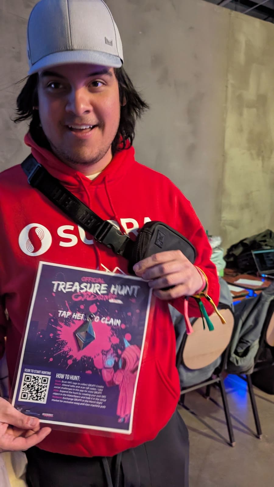 Attendee holding the Official Treasure Hunt flyer with a tap-to-claim QR code